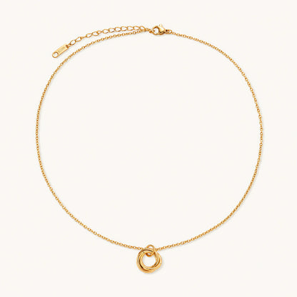 Delicate gold-plated necklace with three interlocking circle rings forming a minimalist knot pendant on cream background